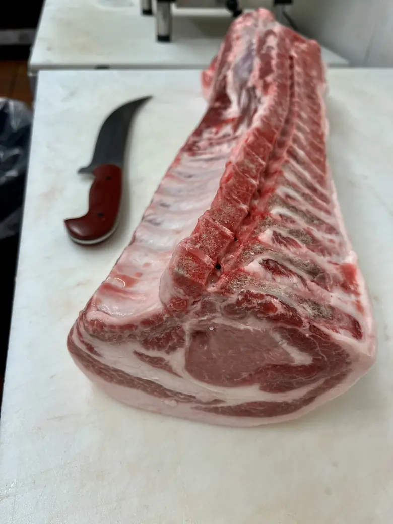A full pork rib section on the block